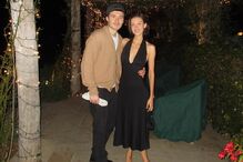 Um casal posa sorridente num ambiente decorado com luzes