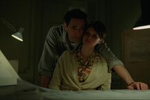 Homem e mulher em ambiente de trabalho, com luz fraca