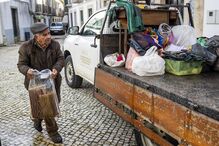 Um homem carrega pertecences para uma carrinha de uma loja destruída numa zona inundada pelas cheias, na zona ribeirinha de Alcácer do Sal, Setúbal.