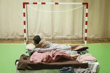 Pessoas deslocadas dormem num ginásio