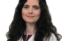 Médica de bata branca posa para fotografia