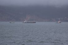 Vista marítima com barcos e montanhas ao fundo