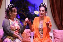 Atrizes em palco com figurino excêntrico e cores vibrantes