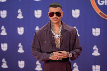 Rauw Alejandro posa no tapete de prémios com óculos de sol e colar de caveira