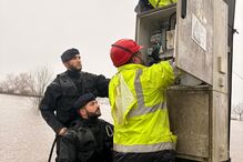 Equipa trabalha em transformador elétrico durante inundações, com apoio da Marinha