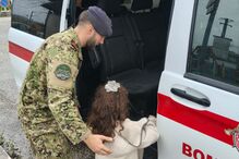 Militar ajuda criança a entrar em carro dos bombeiros