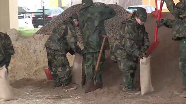 Militares do exército enchem sacos com areia para ajudar vítimas do mau tempo 