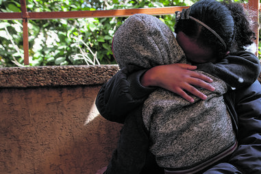 Uma mãe protege o filho dos ataques israelitas em Khan Younis, cidade do Sul do enclave palestiniano 