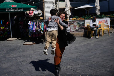 Pessoas correm para se abrigar ao som das sirenes de alerta após o lançamento de um míssil contra Israel, em Tel Aviv