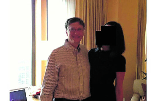 Bill Gates fotografado com uma mulher num interior.
