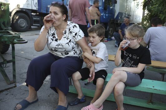 Mulher e filhos descansam enquanto esperam por um ferry para a Crimeia