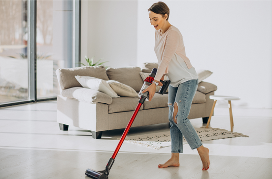 Mulher usa aspirador sem fios para limpar a casa