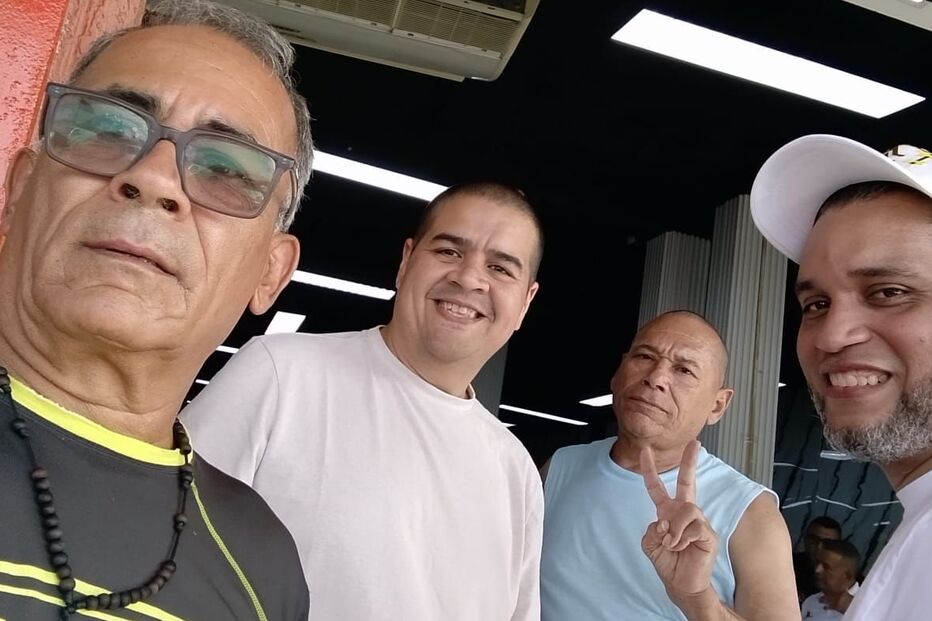 Quatro homens sorriem para a câmara na Venezuela após libertação