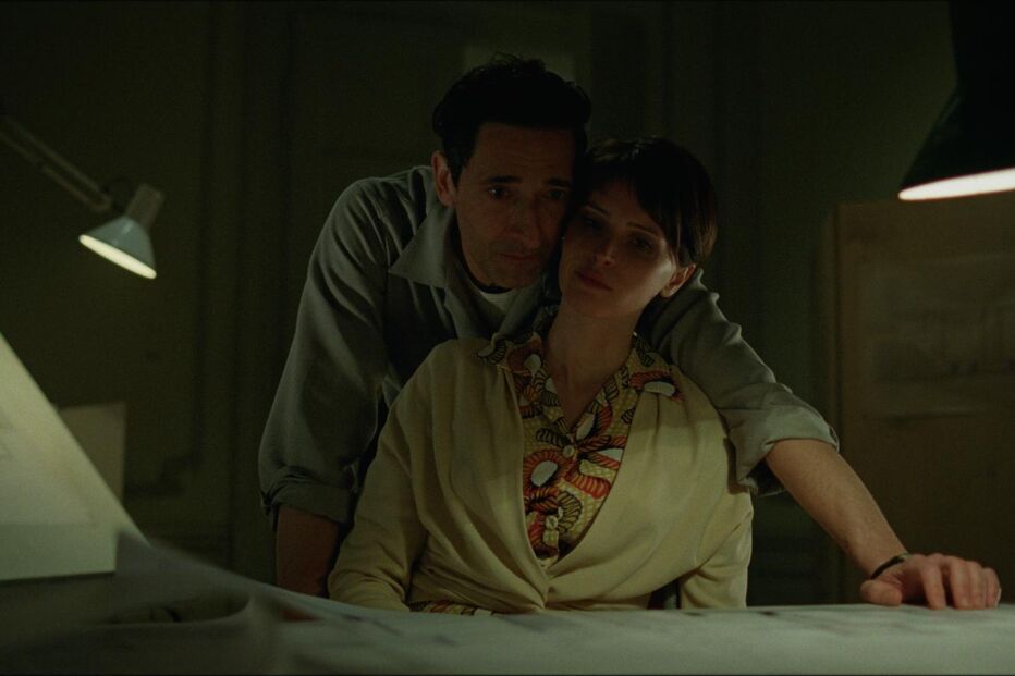 Homem e mulher em ambiente de trabalho, com luz fraca