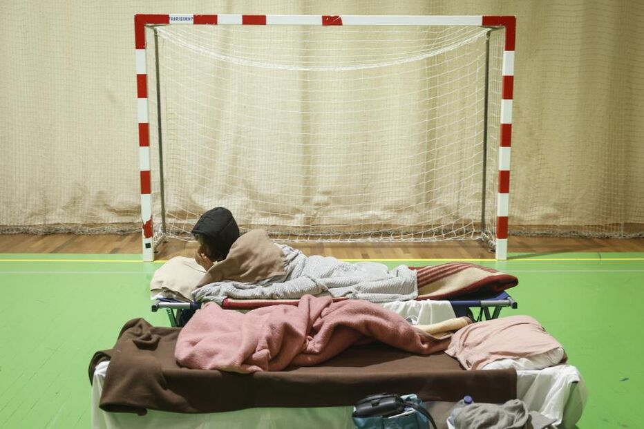 Pessoas deslocadas dormem num ginásio