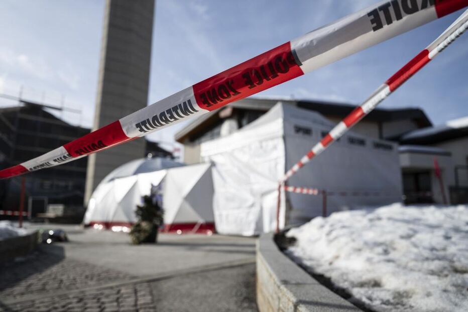 Memorial às vítimas de incêndio num bar na Suíça, com fitas de isolamento da polícia