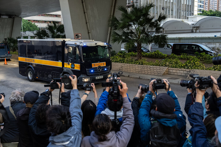 Camião de transporte prisional em Hong Kong, com jornalistas a fotografar