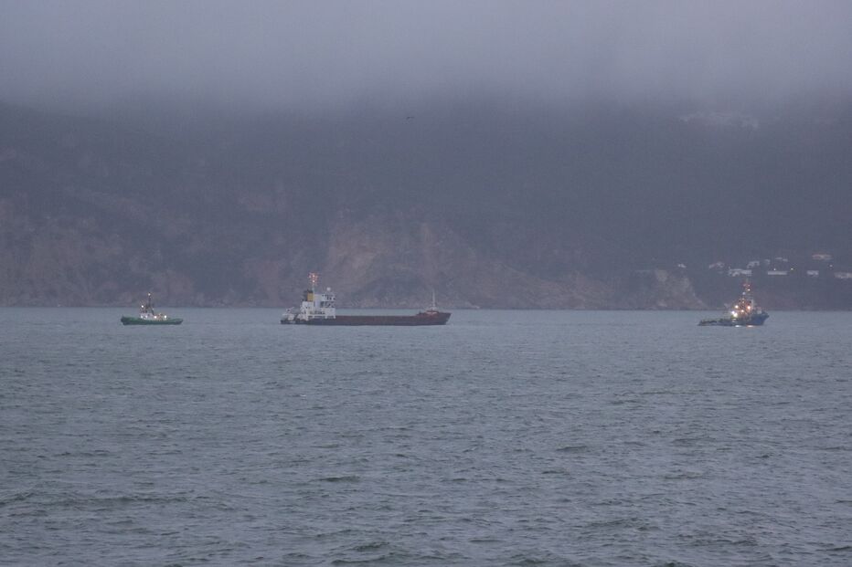 Vista marítima com barcos e montanhas ao fundo