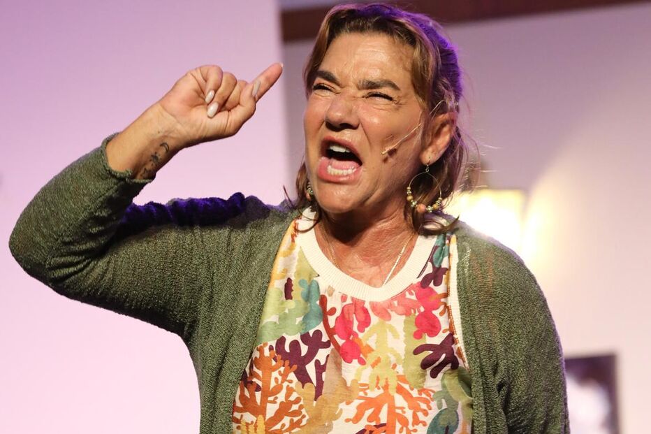Atriz gesticula num palco durante apresentação