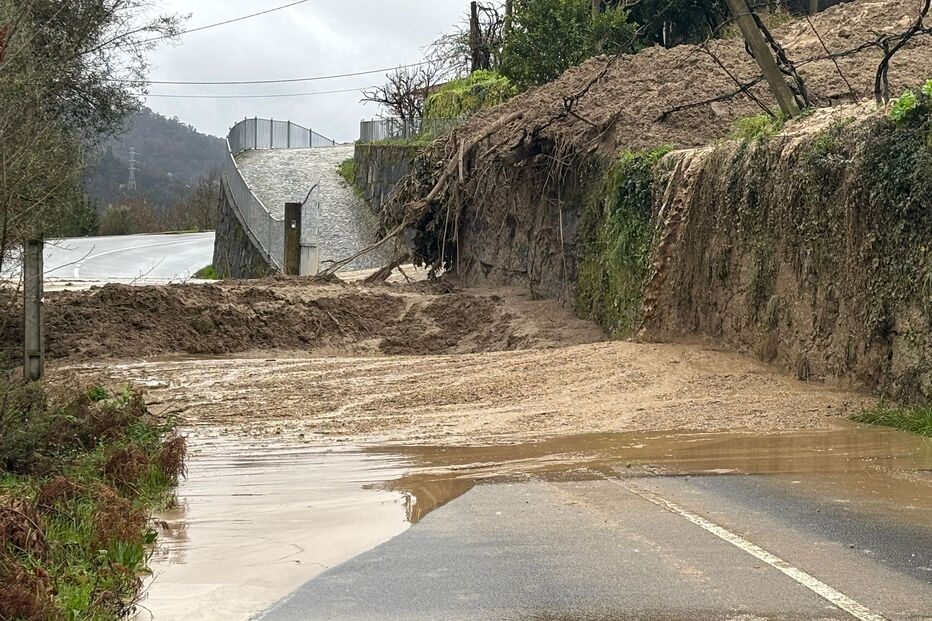 Estrada alagada e cheia de lama após deslizamento de terras
