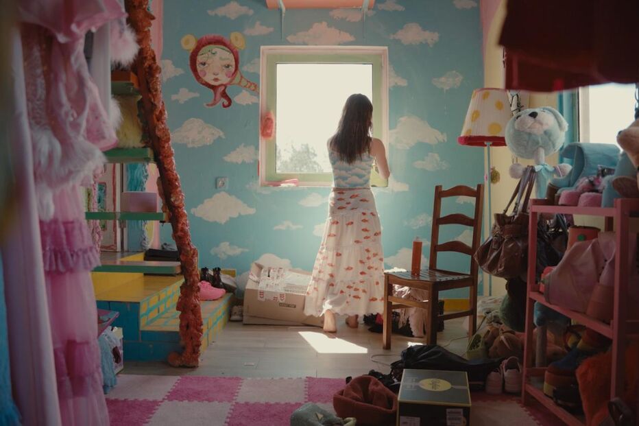 Mulher perto da janela num quarto de 'La Vie de Maria Manuela'.
