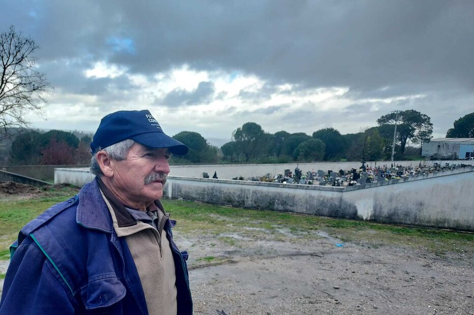 Homem observa cemitério sob céu nublado, num dia outonal