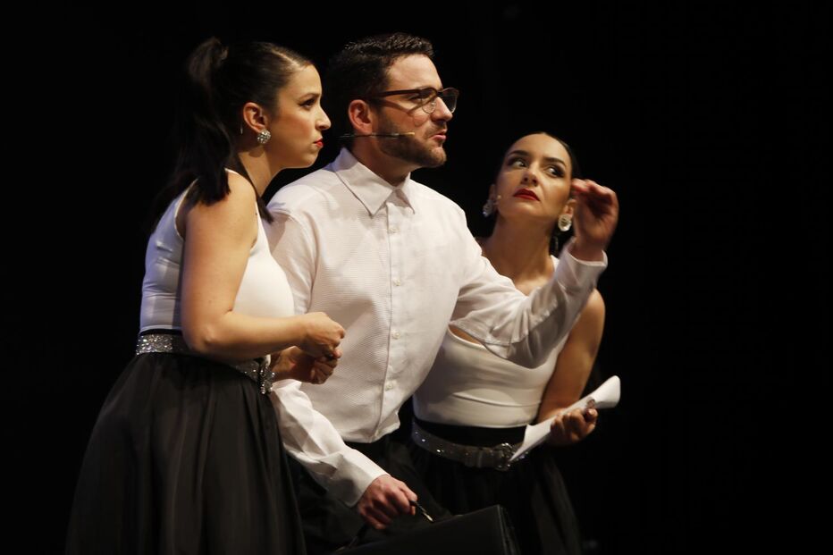 Três pessoas em palco, com figurino a preto e branco, durante uma atuação