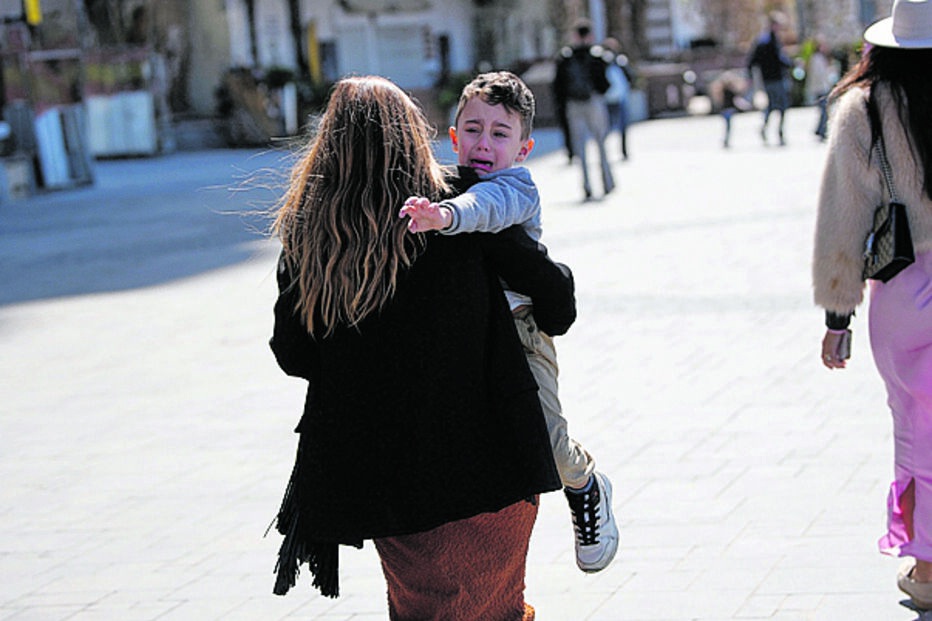 Telavive. Mãe com criança foge para se abrigar enquanto sirenes de alerta soam após o disparo de um míssil em direção à capital israelita