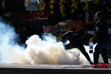 Manifestantes iraquianos perto da embaixada dos EUA em Bagdade com fumo no ar