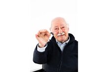 Idoso mostra aparelho auditivo: Dia Mundial da Audição alerta para a saúde auditiva.
