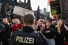 Participantes seguram cartazes contra o regime iraniano em frente à Igreja de São Paulo durante uma manifestação para marcar o Dia Internacional da Mulher, em Hesse, Frankfurt