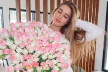 Liza Sudakova em Portugal com ramo de tulipas, enquanto apoia o marido