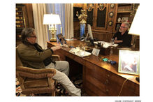 Steve Bannon num escritório, com outra pessoa, mesa de madeira e objetos pessoais