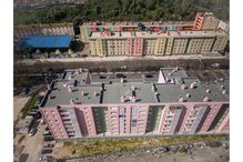 Vista aérea de edifícios coloridos em Lisboa, com tráfego na rua e lixo visível