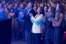 Pessoas assistem a evento e aplaudem