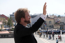 Figura pública saúda multidão em evento numa cidade