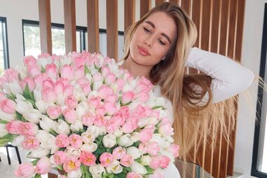 Liza Sudakova em Portugal com ramo de tulipas, enquanto apoia o marido