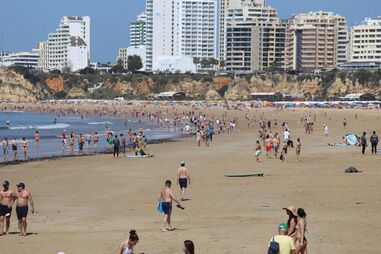 Praia do Algarve cheia de turistas na Páscoa, com hotéis de alta ocupação