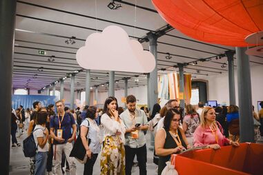 Pessoas reunidas num evento num espaço amplo e decorado