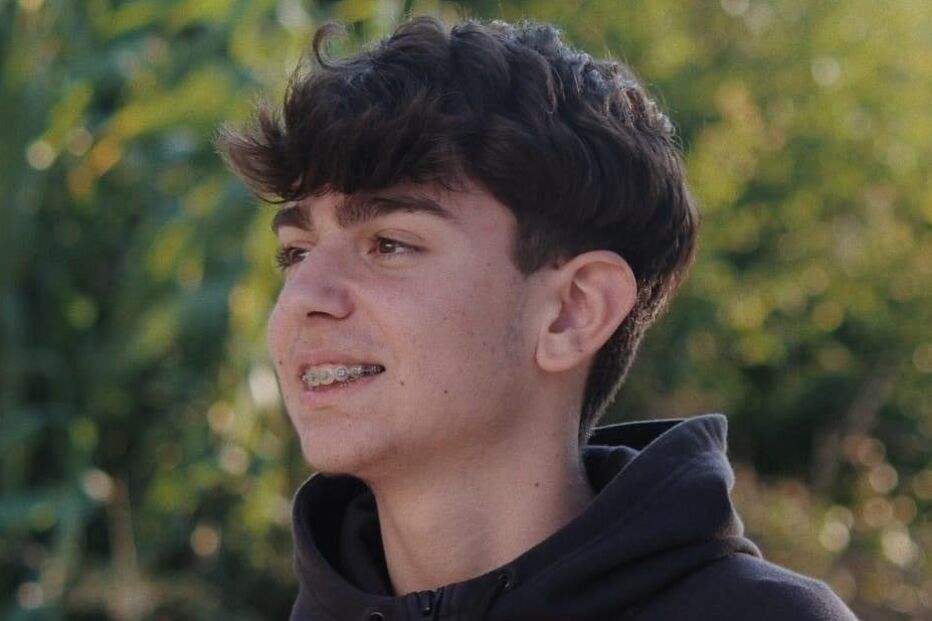 Rapaz com aparelho dentário e camisola da Jordan ao ar livre