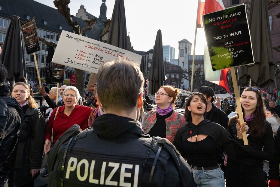 Participantes seguram cartazes contra o regime iraniano em frente à Igreja de São Paulo durante uma manifestação para marcar o Dia Internacional da Mulher, em Hesse, Frankfurt