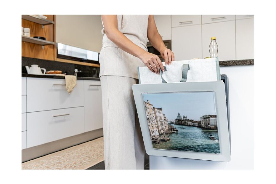 Mulher guarda sacos num suporte com uma imagem de Veneza numa cozinha moderna