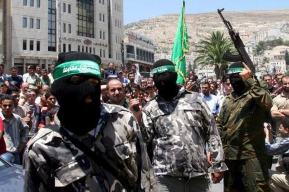 Membros do Hamas mascarados com armas num desfile