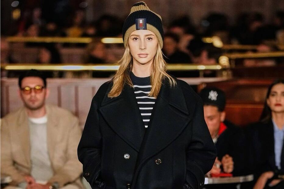 Modelo veste casaco preto, gorro e botas com padrão de cobra