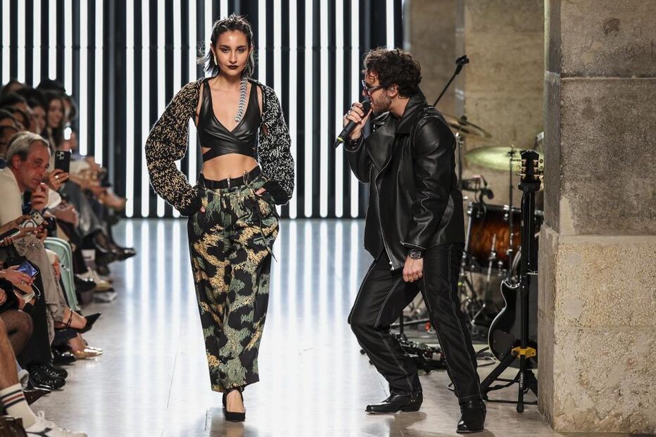 Desfile na ModaLisboa apresenta modelos e banda, celebrando cor e beleza.
