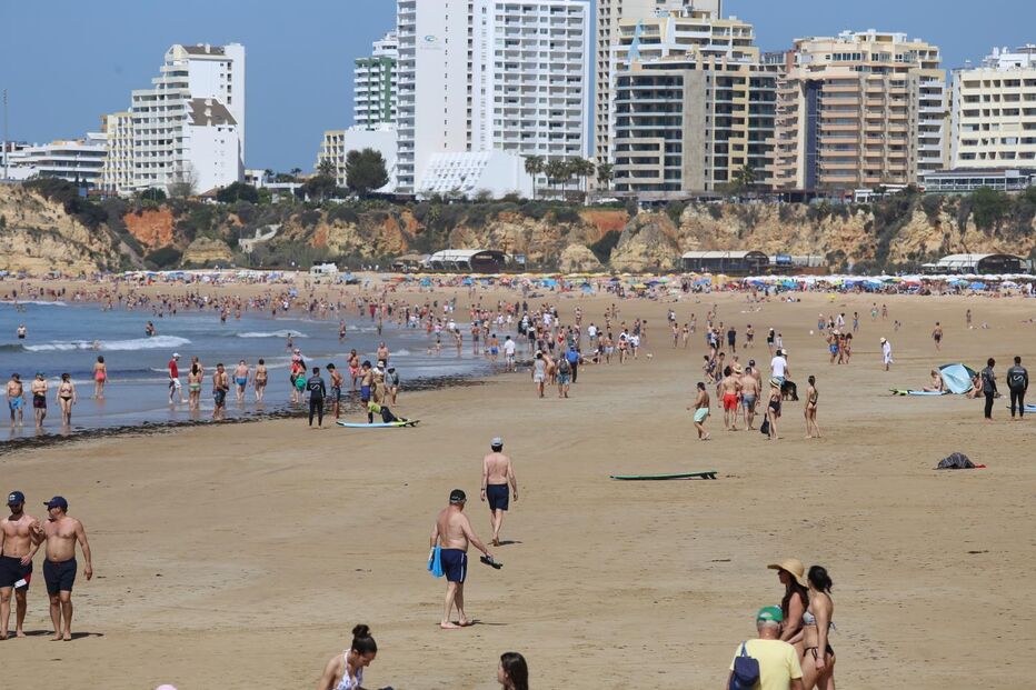 Praia do Algarve cheia de turistas na Páscoa, com hotéis de alta ocupação