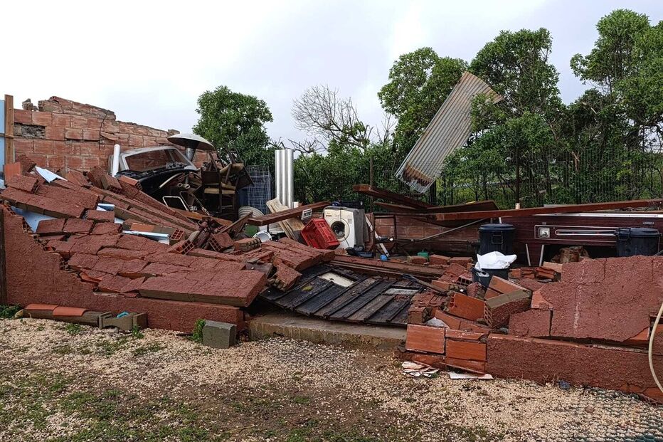 Casa destruída após forte tempestade, com escombros e objetos espalhados