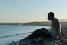 Simão Cayatte estreia 'O Barqueiro' com um homem sentado na praia