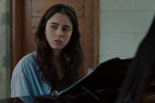 Simão Cayatte lança 'O Barqueiro'. Imagem de mulher ao piano reflete a dualidade do filme.
