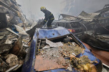 Após ataque, bombeiro inspeciona carros destruídos em Beirute